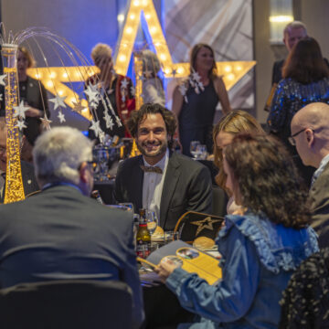 people seated around a table smile at one another