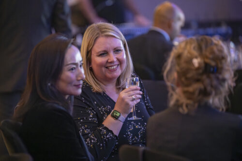 people sip champagne and smile in conversation