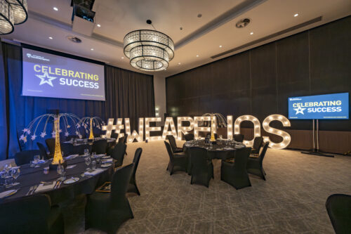 A large room with light-up letters spelling out #weareuos