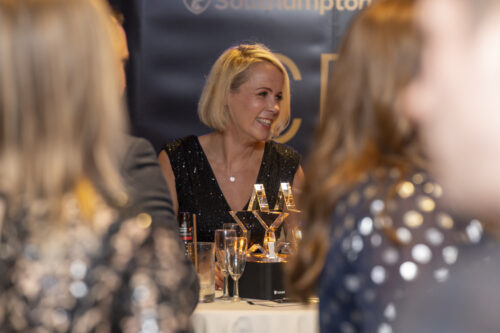 a woman smiling at the people next to her at the table