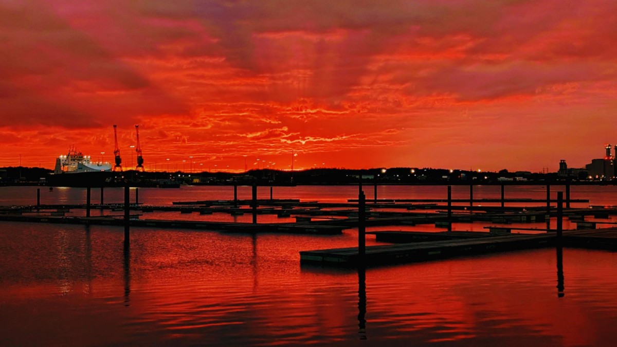 A beautiful red and orange sunset sky over the Solent with the vibrant colours also reflected in the water