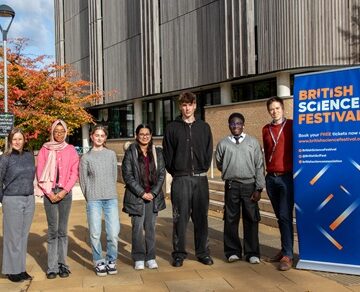 7 people standing in a line next to a pop up banner for the British Science Festival